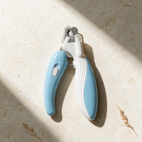 Nailed It pet nail clippers lying on warm travertine stone in soft sunlight